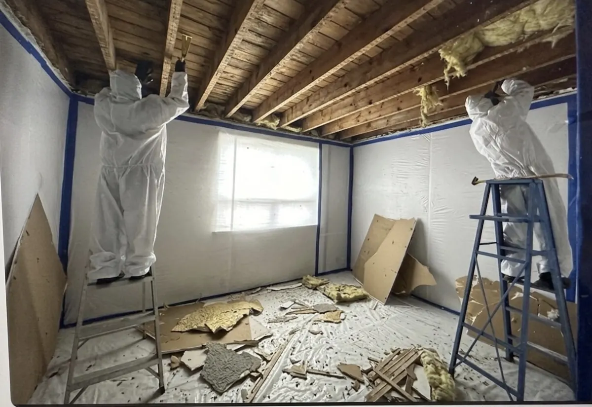 ASAP Pro technicians in PPE removing damaged ceiling and insulation inside a sealed containment